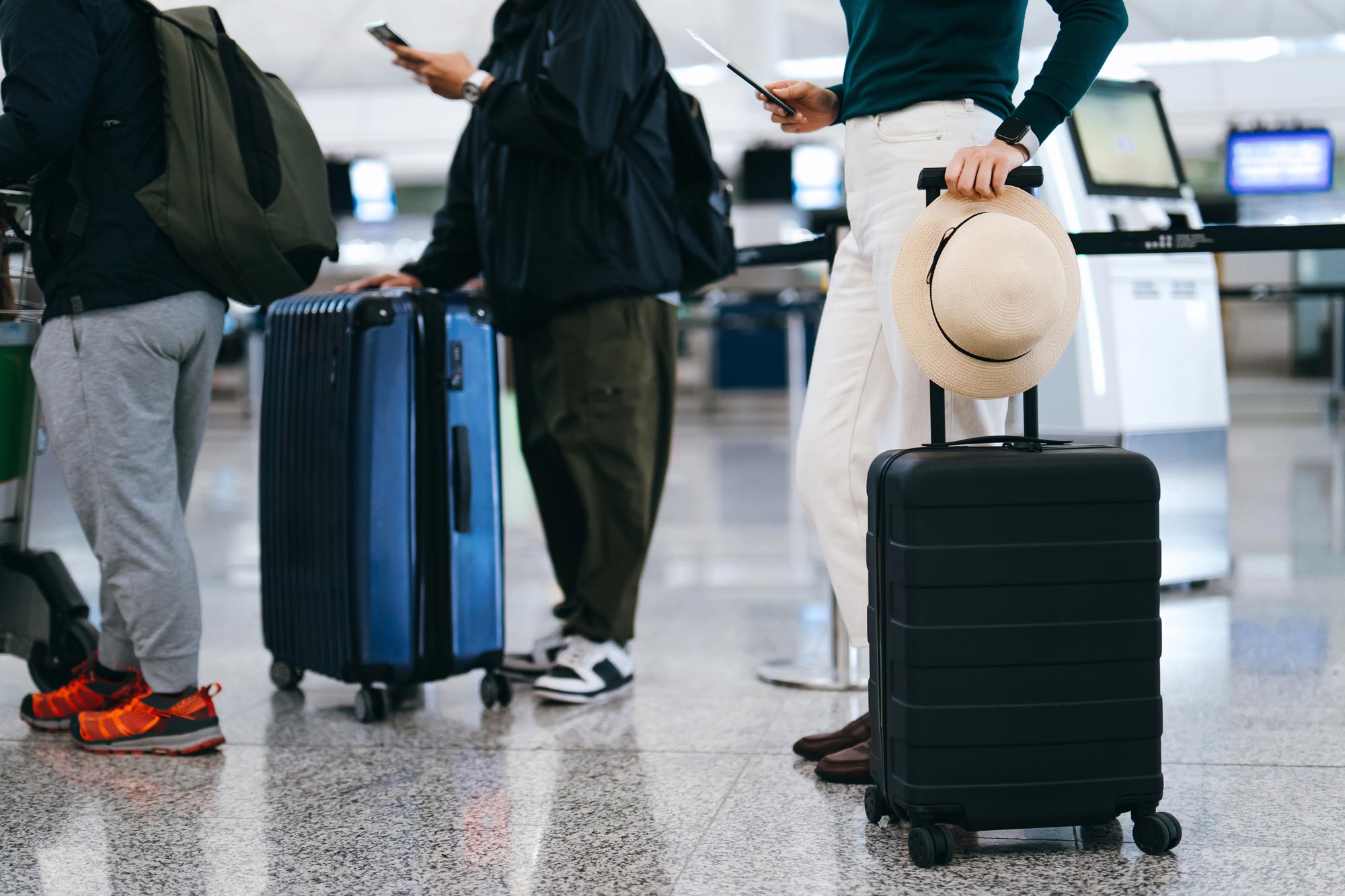 People standing in line with their luggage.