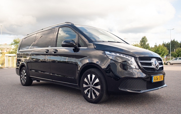 A black Mercedes Benz Van, also known as a luxury limousine.