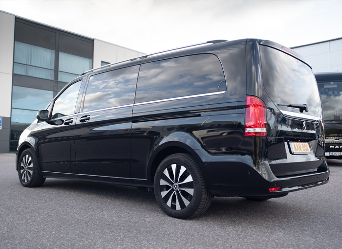 A black Mercedes Benz Van, also known as a luxury limousine.